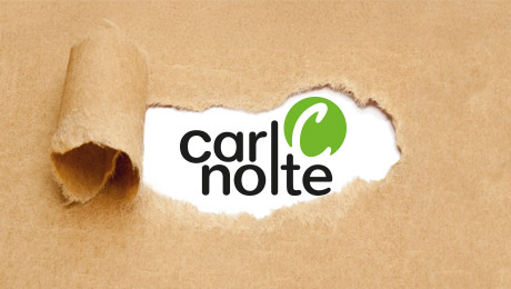 Neu und frisch: Das überarbeitete Logo der Carl Nolte Technik Packpapier, aus dem ein Streifen in der Mitte herausgerissen wurde. Darunter ist das Logo der Carl Nolte Technik zu sehen